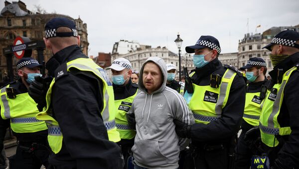 Homem é preso pela policial em protesto contra medidas de isolamento para conter pandemia do coronavírus em Londres - Sputnik Brasil
