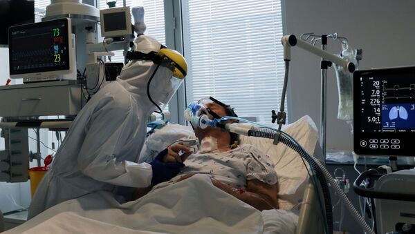 Em Vila Real, Portugal, um profissional de saúde atende um paciente internado com COVID-19 em uma UTI, em 22 de fevereiro de 2021 - Sputnik Brasil