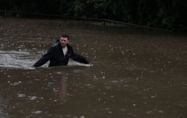 Homem caminha por rua inundada em Sydney, na Austrália - Sputnik Brasil