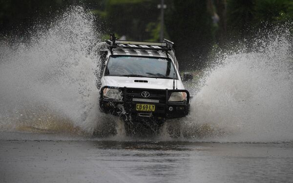 Carro tenta atravessar estrada inundada em Nova Gales do Sul, no sudeste da Austrália - Sputnik Brasil