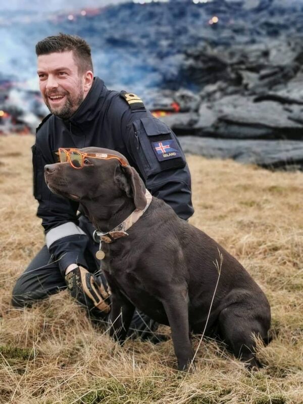 Граннар СигурдссHrannar Sigurdsson, mecânico de aeronaves do esquadrão de helicópteros da Guarda Costeira islandesa, posa para foto com um cachorro encontrado perto da erupção de vulcão na península de Reykjanes na Islândia, 20 de março de 2021 - Sputnik Brasil