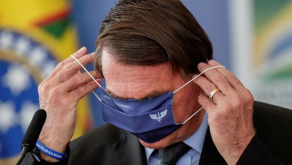 Presidente do Brasil, Jair Bolsonaro, coloca máscara durante cerimônia no Palácio do Planalto, Brasília, 22 de março de 2021  - Sputnik Brasil