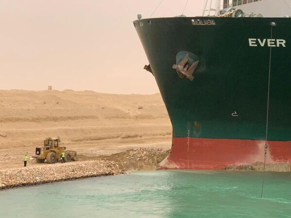 Trabalhadores são vistos ao lado do porta-contêineres que encalhou depois de se desviar da rota devido a ventos fortes no canal de Suez, 24 de março de 2021 - Sputnik Brasil