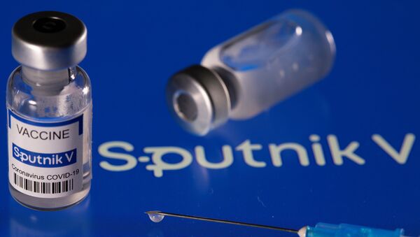Um frasco com a etiqueta da Sputnik V colocado sobre o logotipo da vacina russa em foto de 24 de março de 2021 - Sputnik Brasil