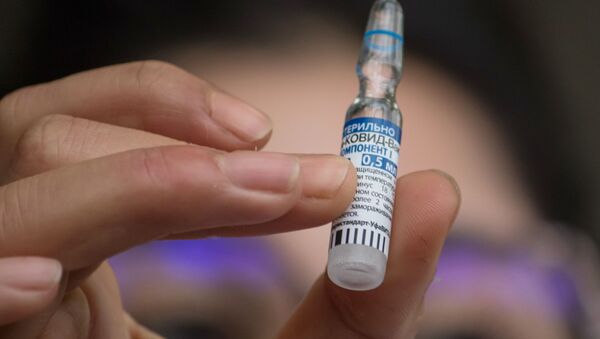 Na Tunísia, um profissional de saúde mostra um frasco da vacina russa Sputnik V contra a COVID-19, em 13 de março de 2021 - Sputnik Brasil