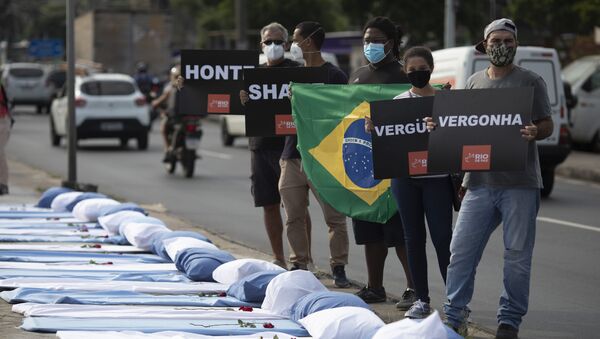 Manifestantes seguram cartazes com mensagem vergonha próximo de leitos simbolizando as vítimas da COVID-19 no Rio de Janeiro durante protesto antigovernamental, 24 de março de 2021 - Sputnik Brasil