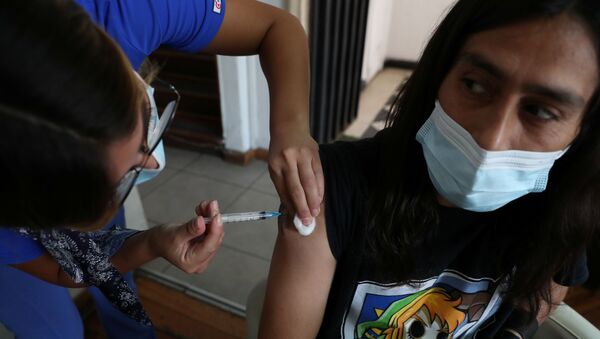 Em Santiago, no Chile, um profissional de saúde aplica uma dose da vacina CoronaVac contra a COVID-19, em 24 de março de 2021 - Sputnik Brasil