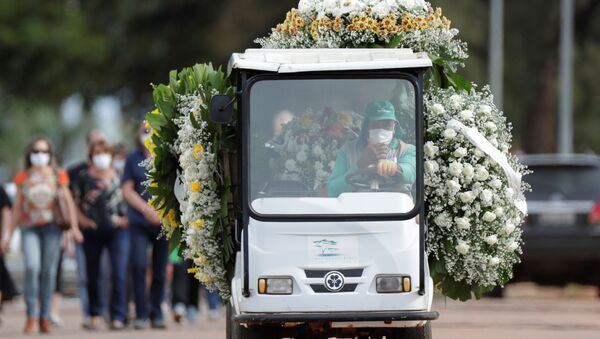 Trabalhador dirige carro com flores e caixão de pessoa falecida por COVID-19, no cemitério Cemitério Campo da Esperança, em Brasília, no Brasil, no 11 de março de 2021 - Sputnik Brasil