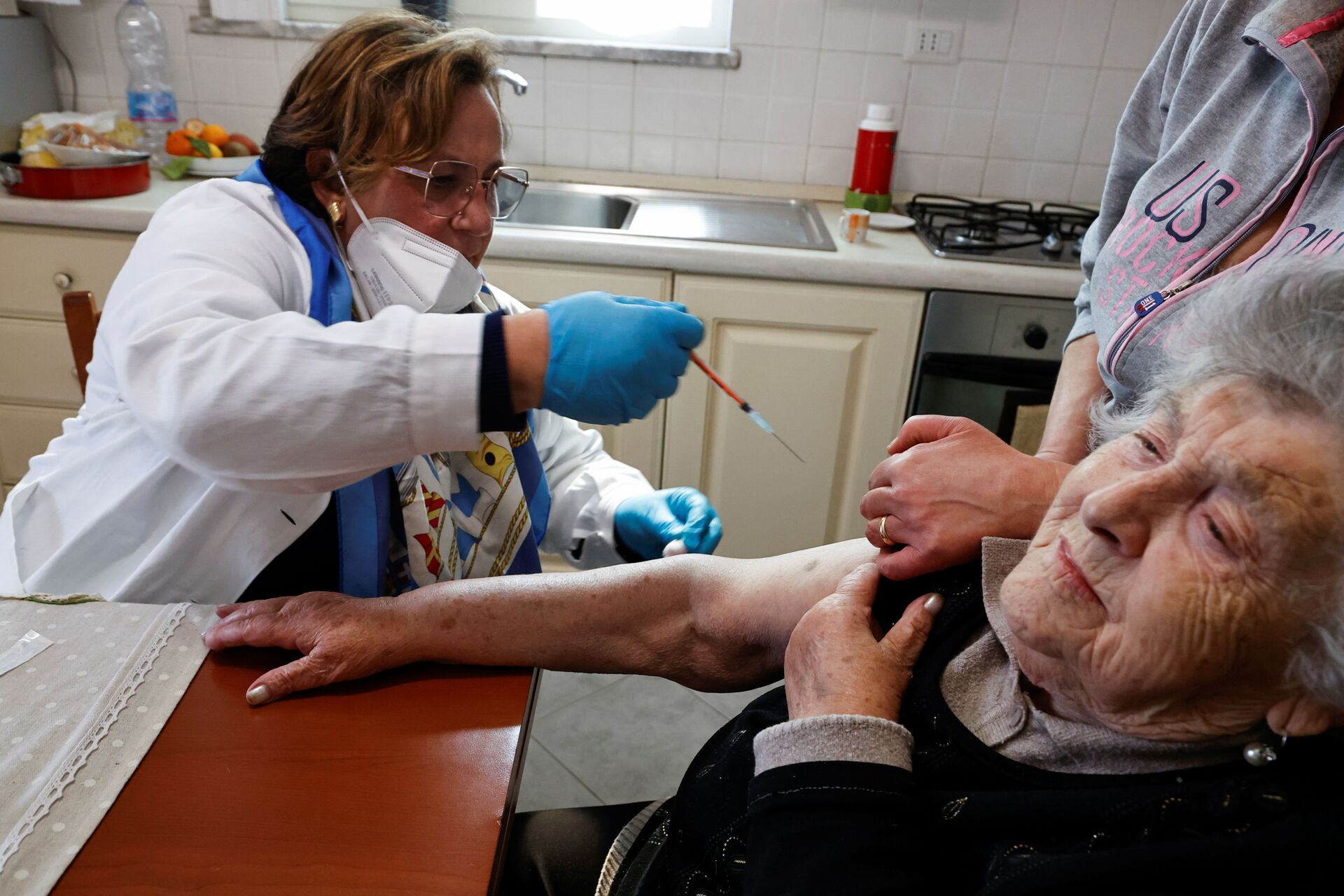 Em Nápoles, na Itália, uma profissional de saúde aplica uma vacina contra a COVID-19 em uma idosa, em 30 de março de 2021 - Sputnik Brasil, 1920, 27.12.2021