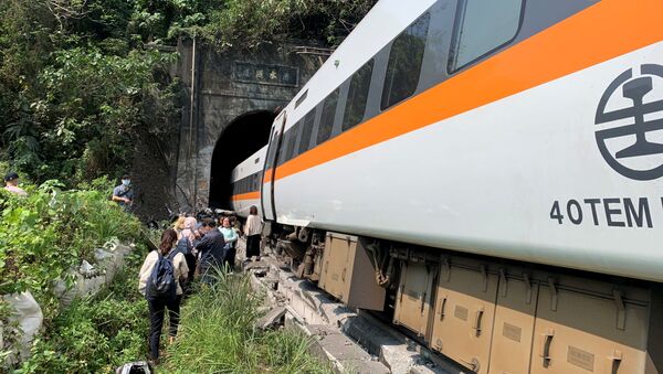 Pessoas caminham ao lado do trem que descarrilou em um túnel a norte de Hualien - Sputnik Brasil