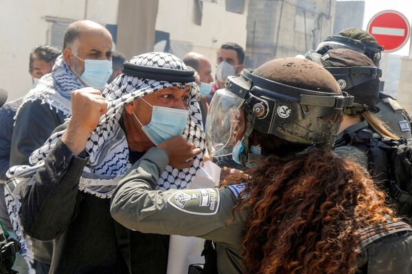 Manifestante palestino briga com uma guarda de fronteira israelense durante protestos no Dia da Terra Palestina em Sebastia, na Cisjordânia, 30 de março de 2021 - Sputnik Brasil