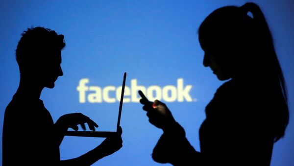 Pessoas utilizando as redes sociais com o logo do Facebook ao fundo - Sputnik Brasil