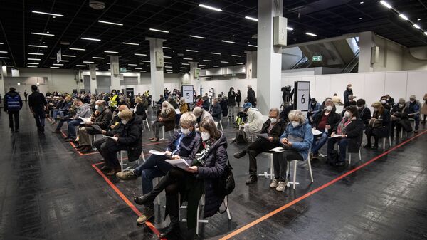 Em Colônia, na Alemanha, pessoas esperam de máscara em um centro de vacinação contra a COVID-19, em 4 de abril de 2021 - Sputnik Brasil