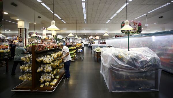 Cliente perto de prateleiras cobertas de plástico para ocultar produtos não essenciais proibidos para venda em supermercado devido às restrições da COVID-19, Porto Alegre, Brasil, 9 de março de 2021 - Sputnik Brasil