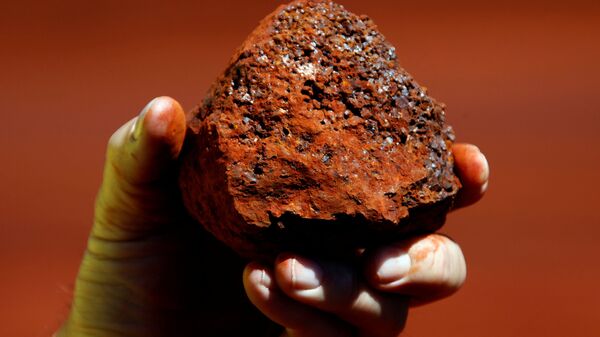 Um minerador detém um pedaço de minério de ferro em uma mina localizada na região de Pilbara, no oeste da Austrália, 21 de março de 2021 - Sputnik Brasil
