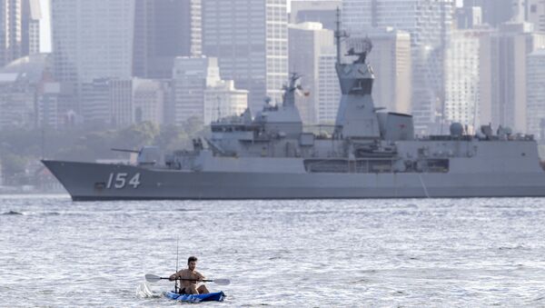 Homem rema em um caiaque tendo ao fundo o navio de guerra australiano HMAS Arunta - Sputnik Brasil
