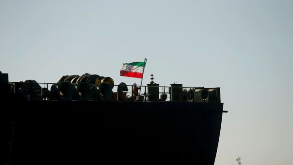 Um tripulante levanta a bandeira iraniana no navio petroleiro Adrian Darya 1, enquanto o navio ainda está ancorado: a Suprema Corte do território britânico ordenou sua retirada, no Estreito de Gibraltar, em 18 de agosto de 2019 - Sputnik Brasil