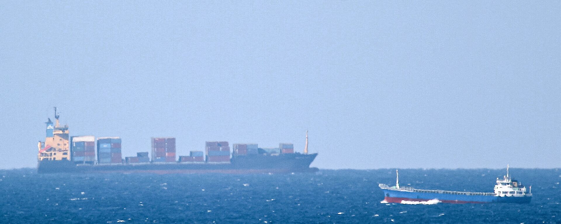 Um navio de carga não identificado navega em direção ao estreito de Ormuz ao largo da costa de Khasab, Omã (foto tirada em 15 de janeiro de 2012). O Irã informou que seu navio Saviz ficou danificado após sofrer uma explosão no mar Vermelho - Sputnik Brasil, 1920, 05.02.2024