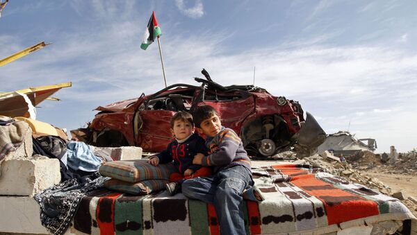 Filhos de uma família palestina descansam em meio aos escombros de sua casa destruída no leste de Jebaliya, norte da Faixa de Gaza, terça-feira, 27 de janeiro de 2009. - Sputnik Brasil