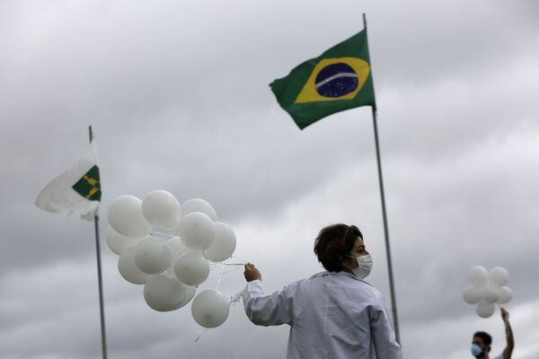 Enfermeira segurando balões em homenagem às vítimas da COVID-19 no Brasil, Brasília, 7 de abril de 2021 - Sputnik Brasil