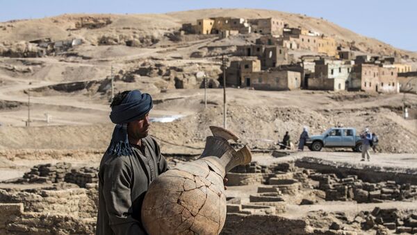 Operário carrega vaso no sítio arqueológico da cidade dourada desenterrada em Luxor, no Egito, 10 de abril de 2021  - Sputnik Brasil