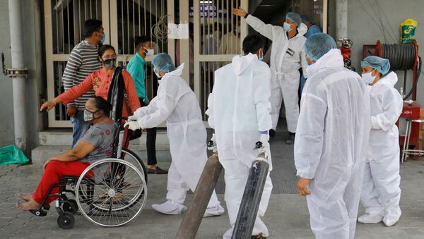Funcionário de saúde carrega cilindros de oxigênio em um hospital para tratar casos da COVID-19 em Amedabade, Índia, 14 de abril de 2021 - Sputnik Brasil