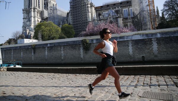 Mulher correndo em frente da catedral de Notre-Dame de Paris, França, 15 de abril de 2021 - Sputnik Brasil