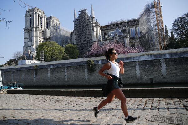 Mulher correndo em frente da catedral de Notre-Dame de Paris, França, 15 de abril de 2021 - Sputnik Brasil