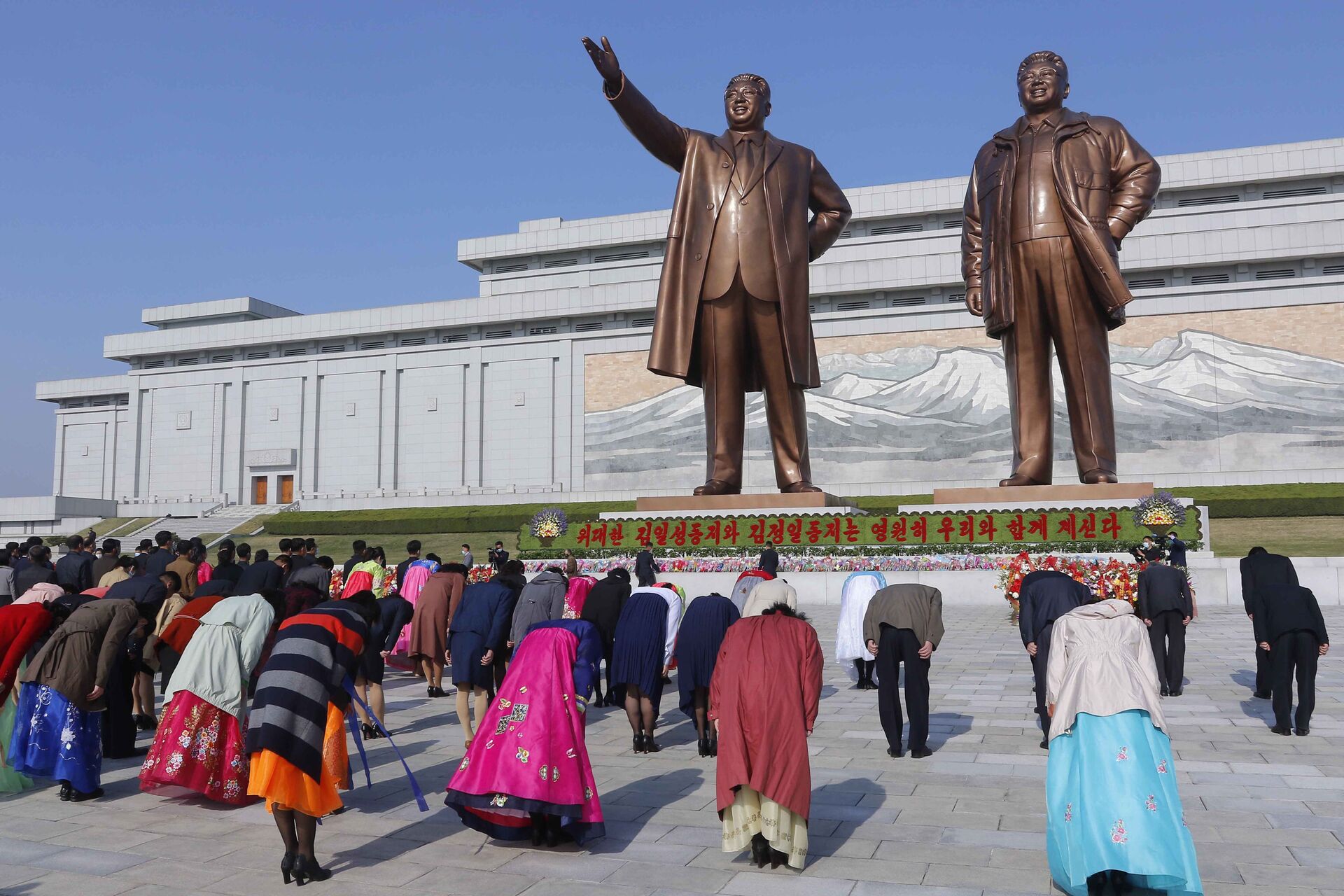 Norte-coreanos fazem reverência oriental diante de estátuas dos líderes Kim Il-sung, fundador do país, e seu filho Kim Jong-il, no Dia do Sol - Sputnik Brasil, 1920, 07.02.2022