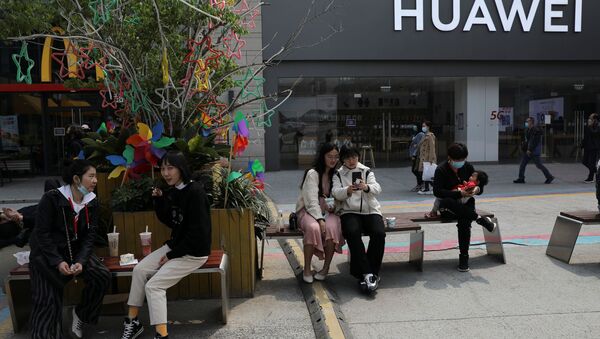 Pessoas descansam em frente a uma loja da Huawei em um shopping de Pequim, China, 15 de abril de 2021 - Sputnik Brasil