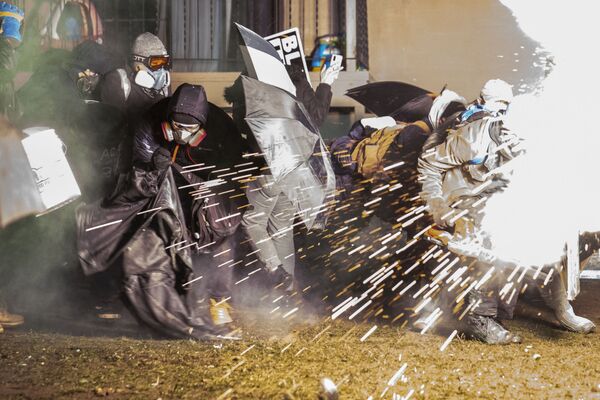 Manifestantes se escondem de munições antimotim disparadas pela polícia durante protestos em Minnesota, 13 de abril de 2021 - Sputnik Brasil