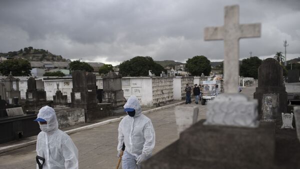 Trabalhadores com equipamento de proteção contra a COVID-19 caminham no cemitério de Inahuma, no Rio de Janeiro, em 15 de abril 2021 - Sputnik Brasil