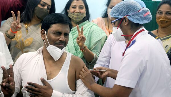 Em Mumbai, na Índia, um homem é vacinado contra a COVID-19 por um profissional de saúde, em 16 de janeiro de 2021 - Sputnik Brasil