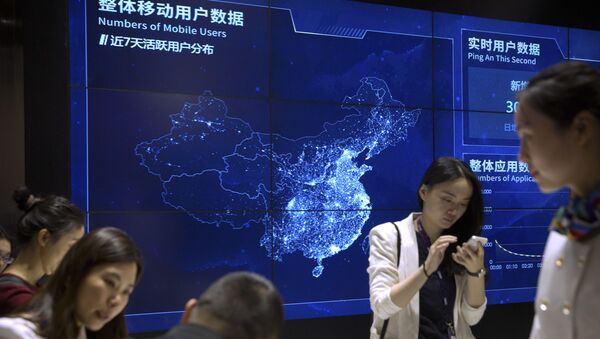 Visitantes usam seus smartphones em frente a uma tela que mostra usuários de telefones celulares na China. O setor de telefonia é um dos que mais sofre com a falta de semicondutores (foto de arquivo) - Sputnik Brasil