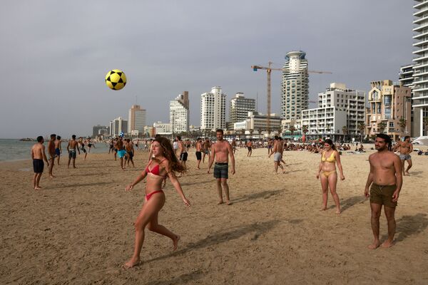 Pessoas jogam futebol na praia de Tel Aviv, Israel, 19 de abril de 2021, após o governo ter anunciado que não é mais necessário usar máscaras no exterior - Sputnik Brasil