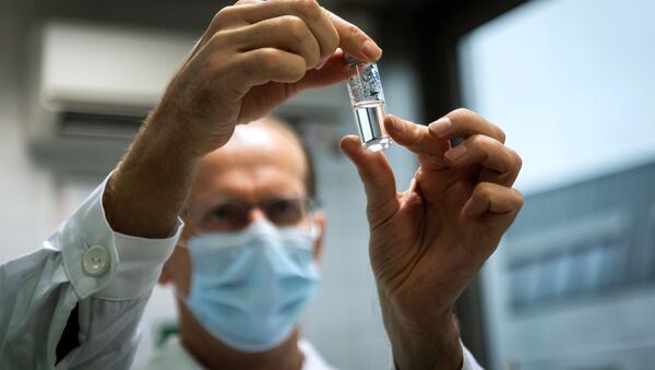 Em Budapeste, na Hungria, um assistente de laboratório segura um frasco da vacina russa Sputnik V contra a COVID-19, em 19 de novembro de 2020 - Sputnik Brasil