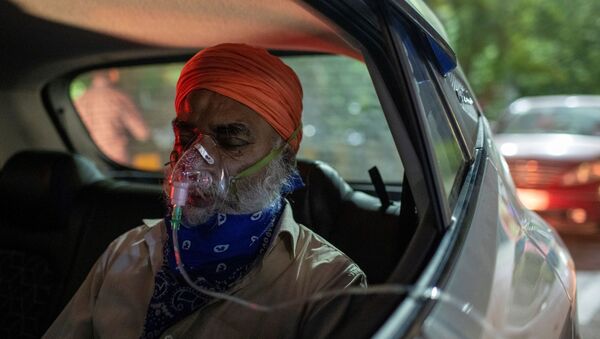 Em Ghaziabad, na Índia, um homem com problemas respiratórios recebe oxigênio dentre de um carro em meio ao pico da COVID-19 no país, em 24 abril de 2021 - Sputnik Brasil