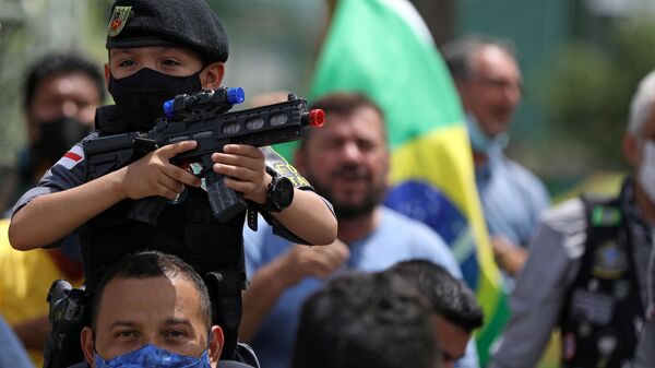 Garoto aponta arma de brinquedo durante protesto contra o presidente Jair Bolsonaro, em Manaus, 23 de abril de 2021  - Sputnik Brasil