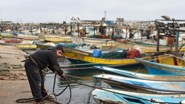 Um pescador palestino amarra um barco após Israel restringir a zona de pesca palestina em resposta aos foguetes palestinos, no porto da Cidade de Gaza em 26 de abril de 2021 - Sputnik Brasil