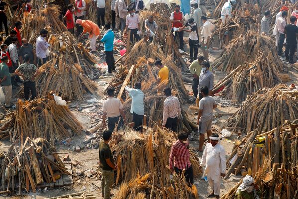 Em Nova Deli, na Índia, pessoas preparam piras funerárias para a cremação de corpos de pessoas infectadas com a COVID-19, em 26 de abril de 2021 - Sputnik Brasil