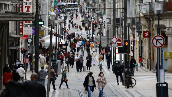 Na cidade do Porto, em Portugal, pessoas caminham nas ruas em dia de comércio aberto em meio à pandemia da COVID-19, em 19 de abril de 2021 - Sputnik Brasil