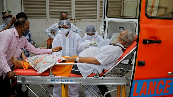 Um paciente com máscara de oxigênio é levado para dentro de um hospital COVID-19 para tratamento, em meio à disseminação da doença do coronavírus em Ahmedabad, Índia, dia 26 de abril de 2021 - Sputnik Brasil