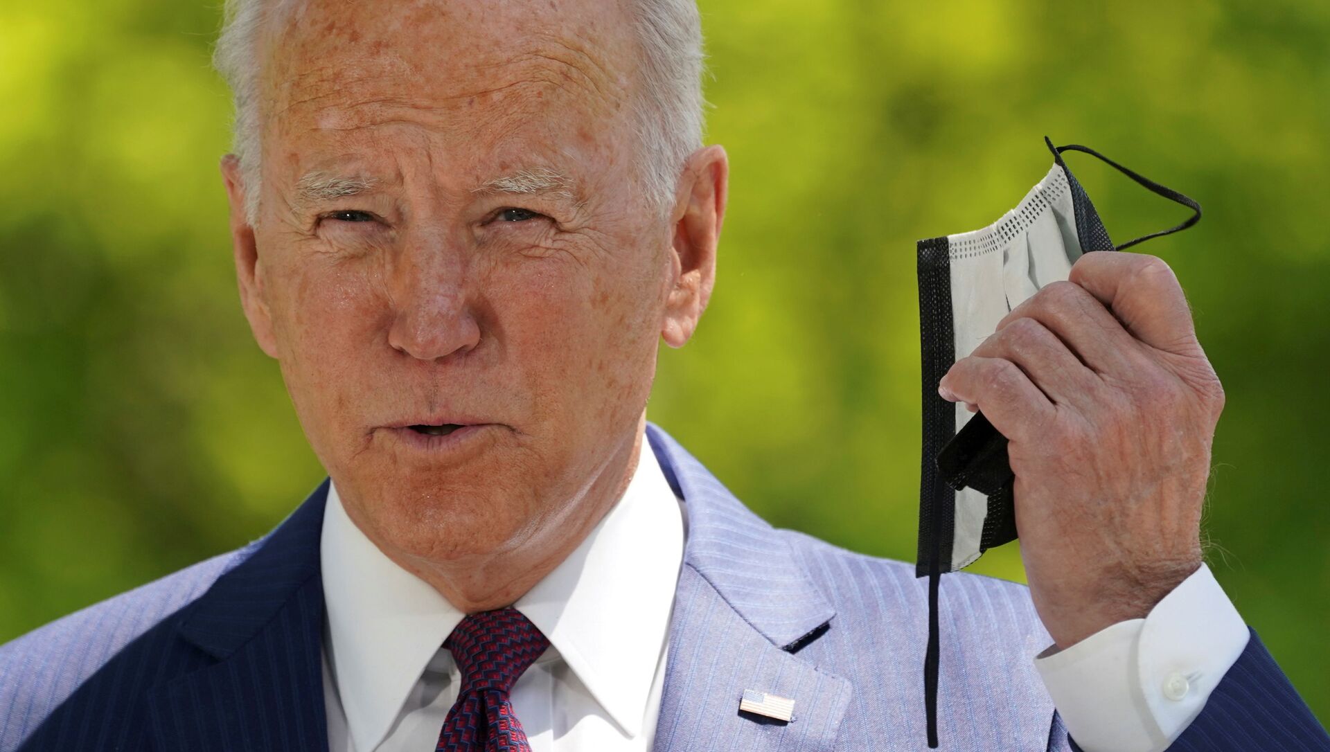 Em Washington, o presidente dos Estados Unidos, Joe Biden, tira a máscara de proteção contra a COVID-19 antes de falar sobre o trabalho de sua administração na pandemia, em 27 de abril de 2021 - Sputnik Brasil, 1920, 13.05.2021