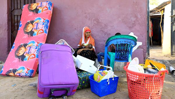 Moradores esperam para fugir após novos confrontos entre facções rivais nas forças de segurança, em Mogadíscio, Somália, 27 de abril de 2021 - Sputnik Brasil
