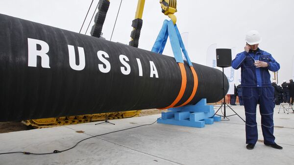 Construtor fala ao telefone ao lado de gasoduto da empresa russa Gazprom, em São Petersburgo, Rússia (foto de arquivo) - Sputnik Brasil