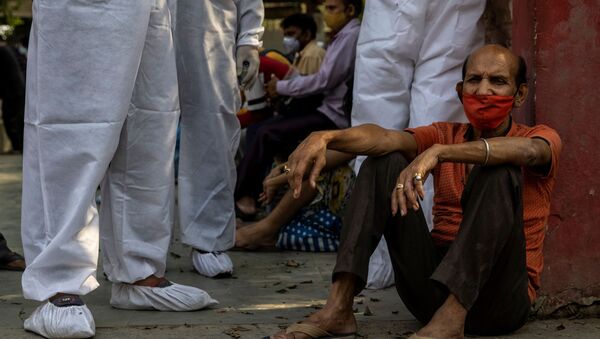 Homem espera para cremar seu parente, que morreu devido à COVID-19, em um crematório em Nova Deli, na Índia - Sputnik Brasil