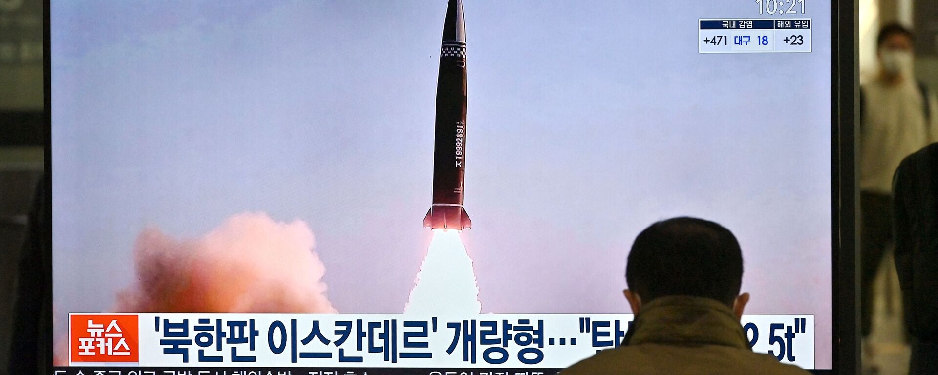 Um homem assiste a uma tela de televisão na estação ferroviária de Suseo, em Seul, em 26 de março de 2021, exibindo imagens de notícias do mais recente teste de projétil tático guiado da Coreia do Norte - Sputnik Brasil, 1920, 28.03.2023