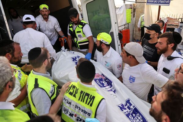 Socorristas colocam o corpo de uma vítima em ambulância na sequência da debandada no monte Meron  
 - Sputnik Brasil