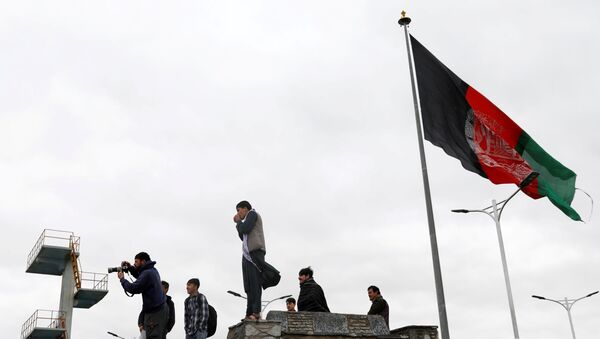Jovens tiram fotos ao lado de uma bandeira afegã no topo de uma colina com vista para Cabul, Afeganistão, 15 de abril de 2021 - Sputnik Brasil