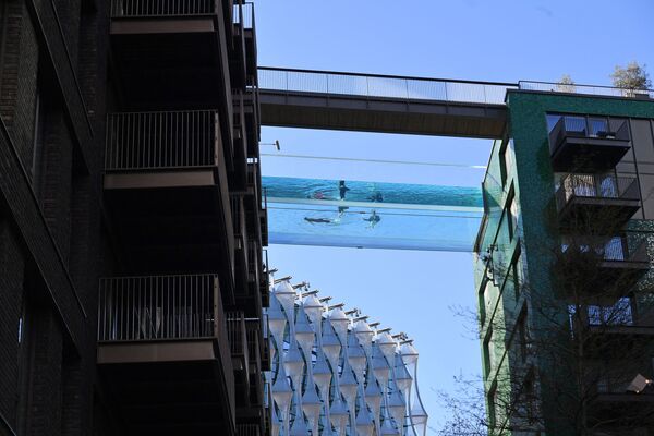 Modelos nadam na primeira piscina transparente aberta de 25 metros chamada de Sky Pool e fixada entre dois prédios de apartamentos, Londres, Reino Unido, 22 de abril de 2021 - Sputnik Brasil